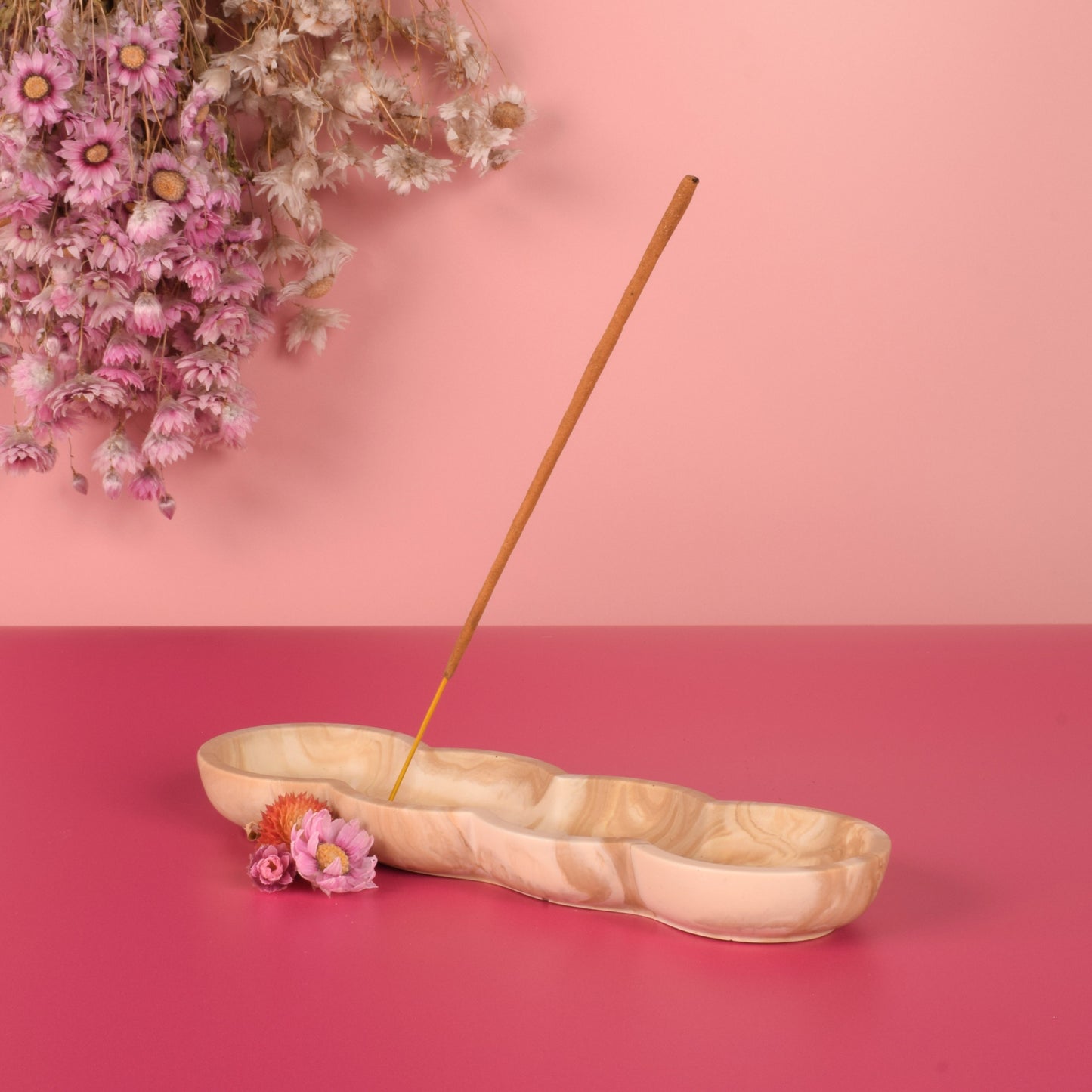 Beige and caramel marbled jesmonite incense holder holding a stick of incense