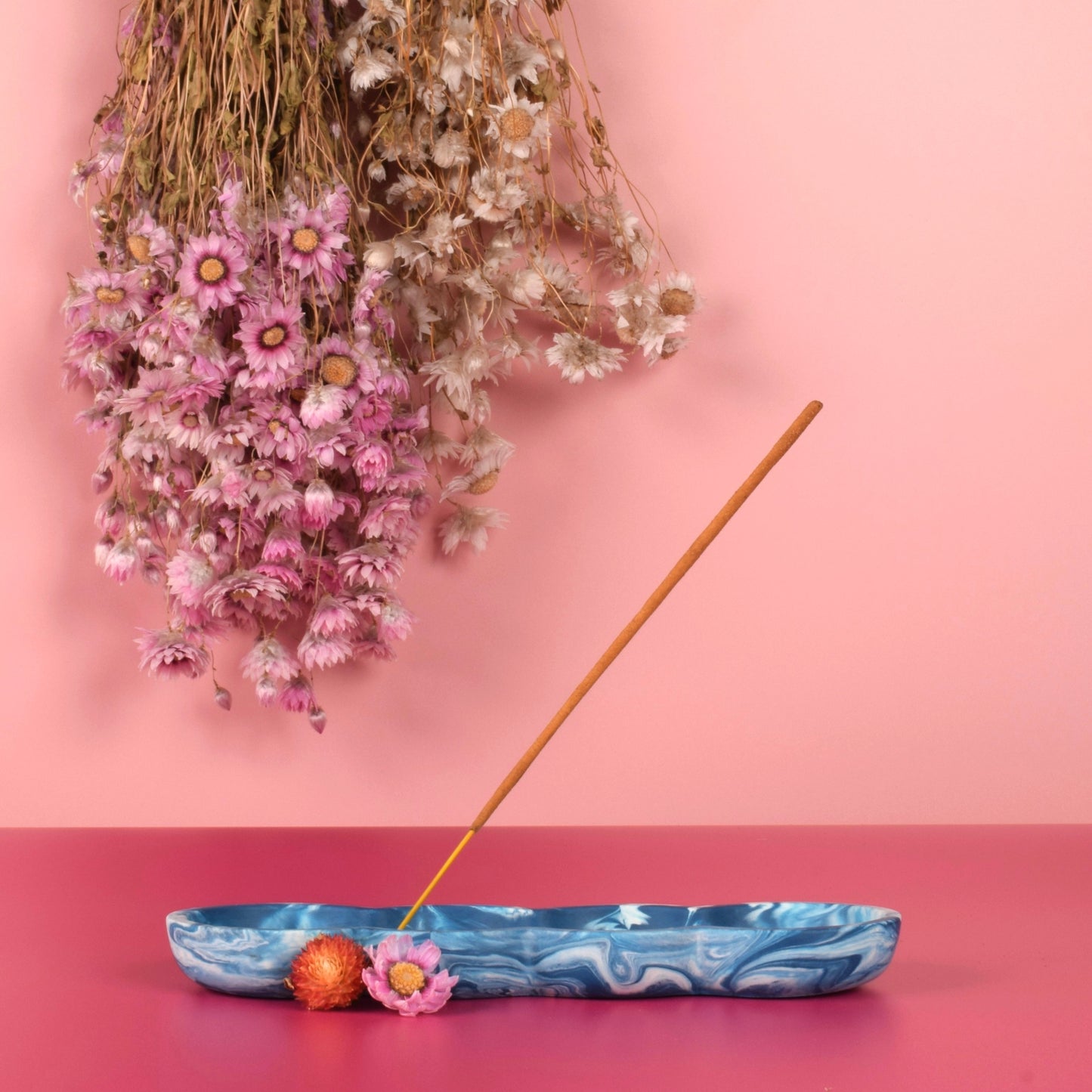 Blue and white marbled jesmonite incense holder holding a stick of incense