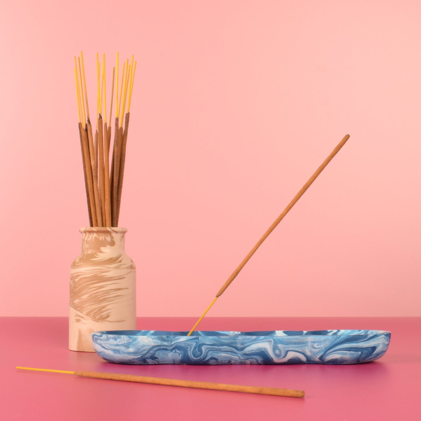 Blue and white marbled jesmonite incense holder holding a stick of incense