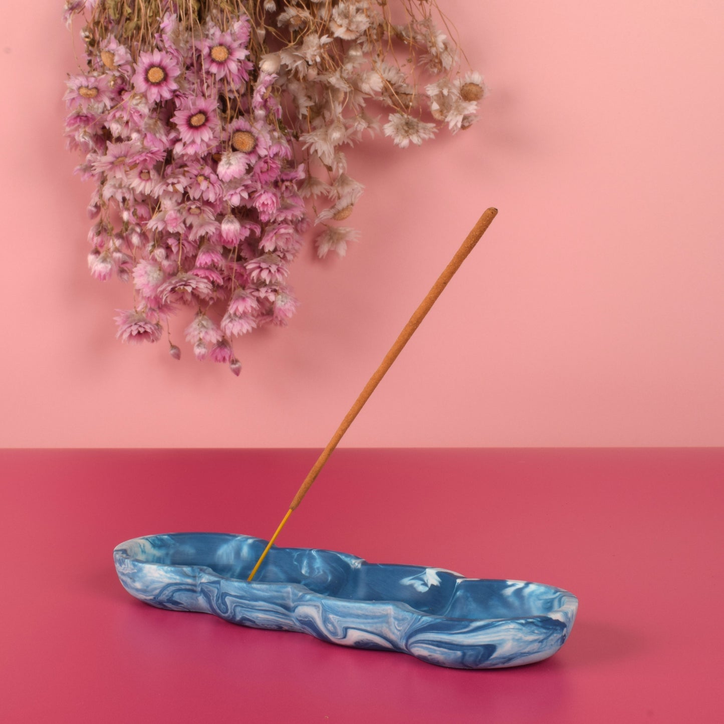 Blue and white marbled jesmonite incense holder holding a stick of incense